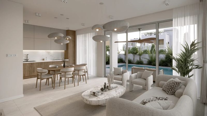 Open-plan living room and kitchen in a new Cyprus apartment, with sliding doors opening to a private pool
